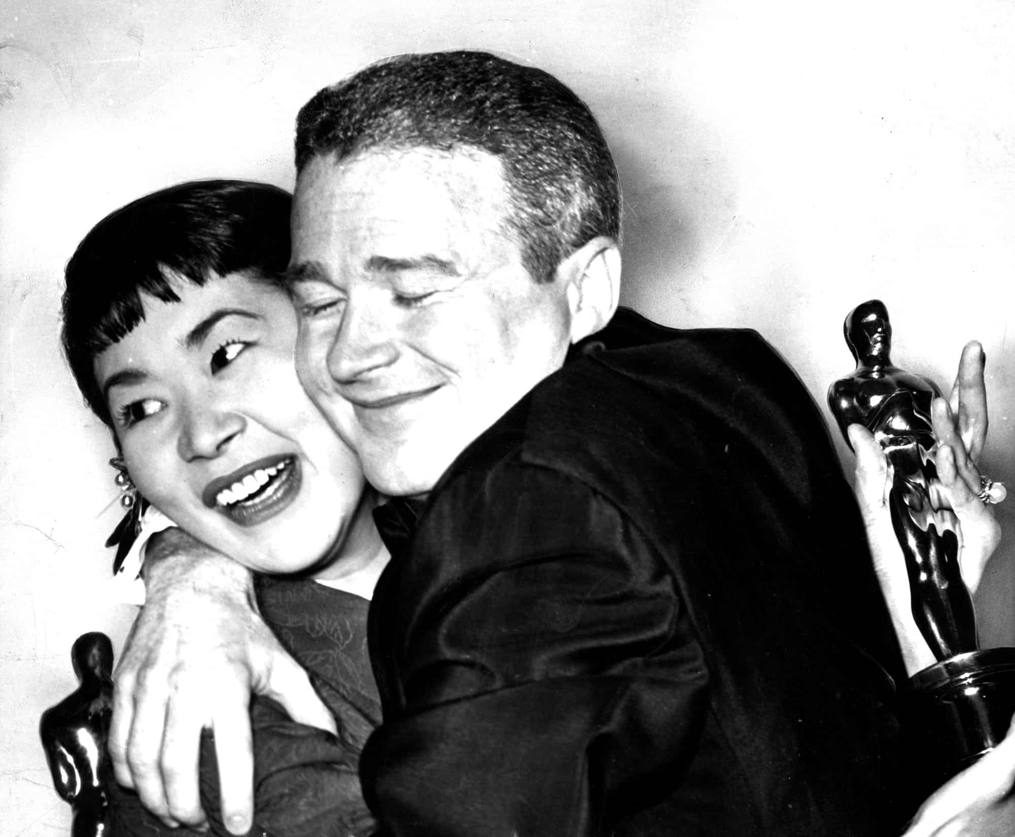Miyoshi Umeki and Red Buttons hold fast to their Oscars as they embrace in joy over winning awards f miyoshi umeki and red buttons hold fast to their oscars as they embrace in joy over winning awards f